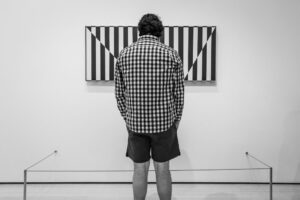 Clark Mishler - Man in Checkered Shirt at a Museum